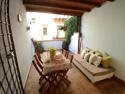 a room with a table and a couch on a balcony at Il terrazzino sul Kemonia in Palermo