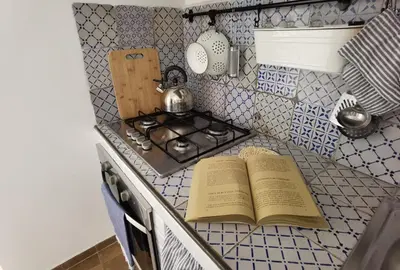 an open book on a kitchen counter next to a stove at Il terrazzino sul Kemonia in Palermo
