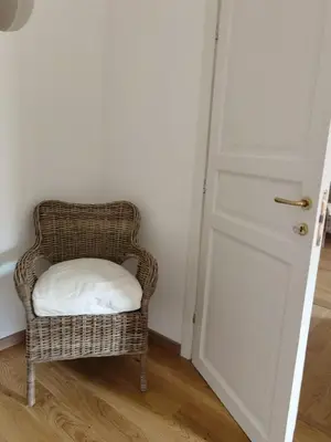 a wicker chair with a white pillow sitting next to a door at Il terrazzino sul Kemonia in Palermo