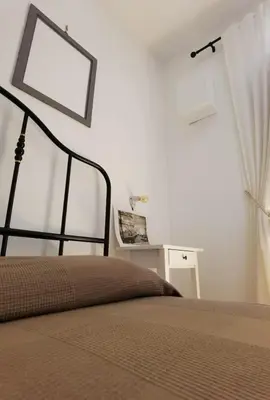 a bedroom with a bed with a picture on the wall at Il terrazzino sul Kemonia in Palermo