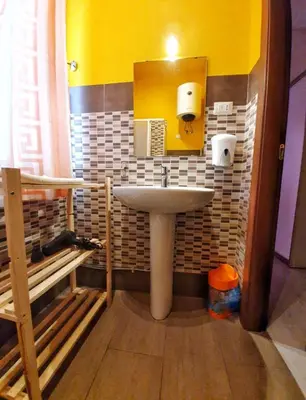 a bathroom with a sink and a yellow wall at A un passo dal centro in Palermo