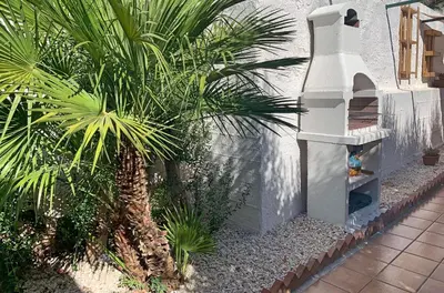 a palm tree and a bird house in a garden at Casa Mandarino in Macari