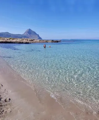 a person standing in the water at the beach at Casa Mandarino in Macari