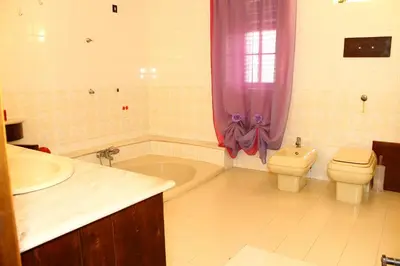 a bathroom with a tub and a toilet and a sink at Villa Porto Rais in Carini