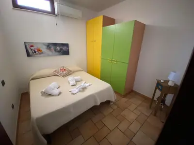 a small room with a bed with a colorful cabinet at Villa Grisì in Partinico