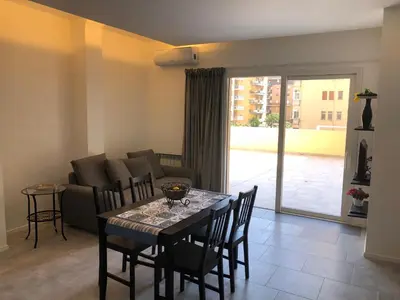 a living room with a table and chairs and a couch at Residenza De Gasperi in Palermo