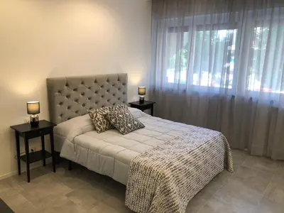 a bedroom with a bed with two tables and a window at Residenza De Gasperi in Palermo