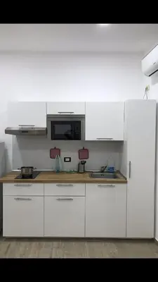 a white kitchen with white cabinets and a microwave at Casa Saline in Mondello