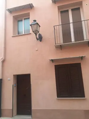 a building with two doors and a lamp on it at Casa Vacanza La Pergola in Terrasini