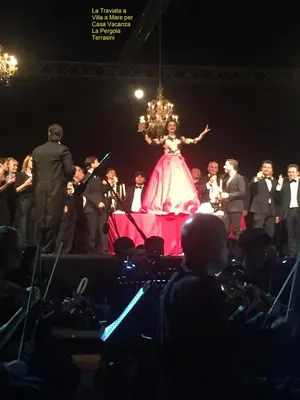 a woman in a dress on a stage with a crowd at Casa Vacanza La Pergola in Terrasini