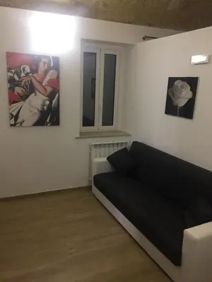 a living room with a couch and two pictures on the wall at Casa Vacanze La Pergola@ in Terrasini