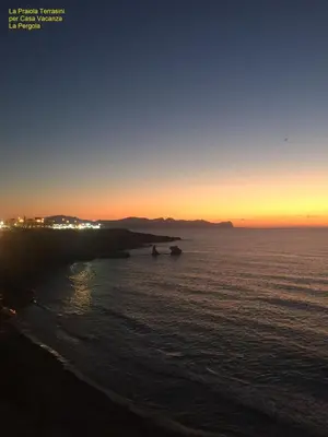 a sunset over the ocean with two boats in the water at Casa Vacanze La Pergola@ in Terrasini