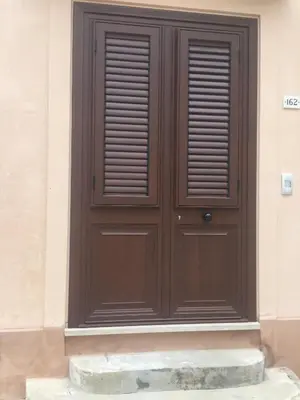 a wooden door on the side of a building at Casa Vacanze La Pergola@ in Terrasini