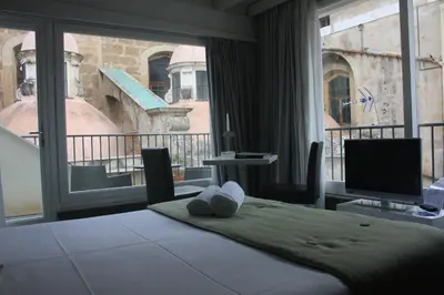 a bedroom with a bed and a large window at Quintocanto Hotel & Spa in Palermo