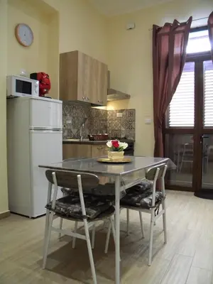 a kitchen with a table and chairs in a kitchen at La Casetta del Viale 13 in Palermo