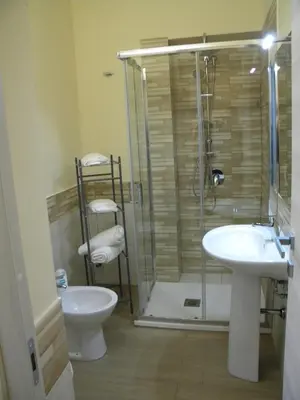 a bathroom with a shower and a toilet and a sink at La Casetta del Viale 13 in Palermo
