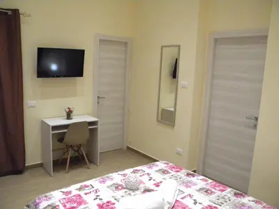 a bedroom with a bed and a desk and a television at La Casetta del Viale 13 in Palermo