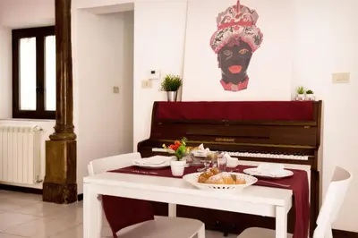 a dining room with a piano and a plate of food at La Casa del Moro in Palermo