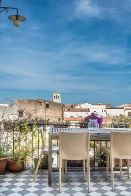 a table with chairs and a view of a city at Palazzo Castrofilippo Apartment by Wonderful Italy in Palermo