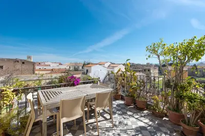 a table and chairs on a balcony with plants at Palazzo Castrofilippo Apartment by Wonderful Italy in Palermo