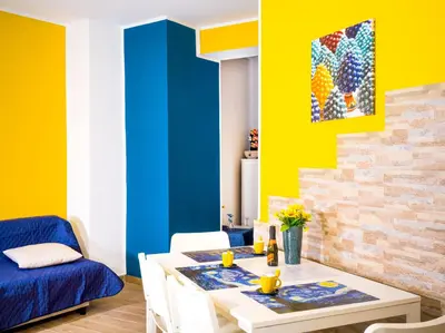 a dining room with a blue and yellow wall at Comfortable studio in Palermo 45 sqm with view in Palermo