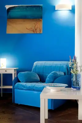 a blue couch in a living room with a table at Affittacamere B&B Carella in Palermo