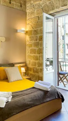 a bedroom with a yellow bed and a brick wall at Affittacamere B&B Carella in Palermo
