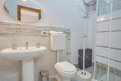 a bathroom with a toilet and a sink and a mirror at Sturzo 44 in Palermo