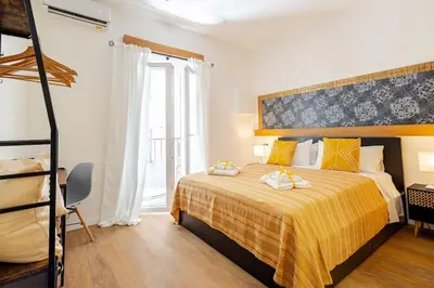 a bedroom with a bed with a yellow bedspread at Alle Antiche Mura del mercato di Ballarò in Palermo