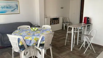 a living room with a table and chairs and a couch at Veranda sul Mare in Castellammare del Golfo