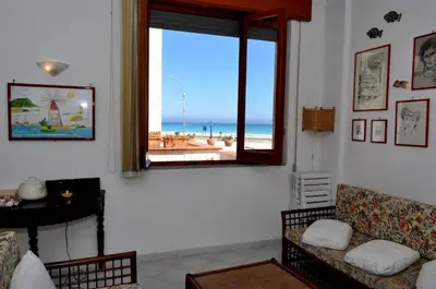 a living room with a window with a view of the beach at Sul lungo mare posizione unica in San Vito lo Capo