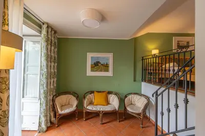 a living room with two chairs and a staircase at Kalamarina Rooms in Palermo
