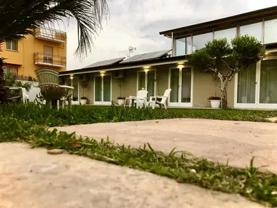 a house with a patio and chairs in the yard at Amantea Monument in Terrasini