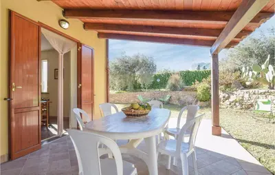 a dining table and chairs on a patio at Casa Sardina in Mandra Capreria