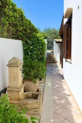 a walkway with potted plants next to a building at Monolocale da Mariolina in Macari