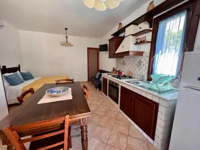 a kitchen with a sink and a table in a room at Monolocale da Mariolina in Macari