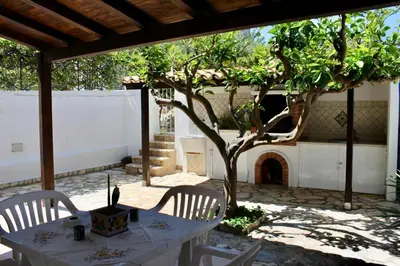 a table and chairs with a tree and a fireplace at Monolocale da Mariolina in Macari