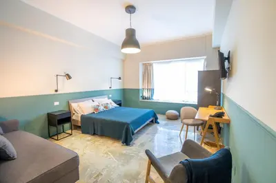 a bedroom with a bed and a table and chairs at Leone Suite B&B & Restaurant AIC in Palermo