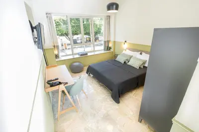a bedroom with a bed and a desk and a window at Leone Suite B&B & Restaurant AIC in Palermo