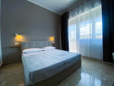a bedroom with a bed and a large window at Leone Suite B&B & Restaurant AIC in Palermo
