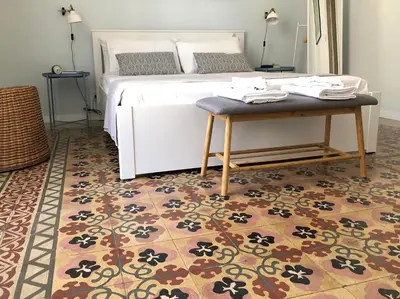 a bedroom with a bed with a table and a rug at Sammartino 108 in Palermo