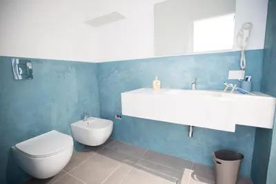 a bathroom with a white sink and a toilet at White Asses Rooms in Castellammare del Golfo