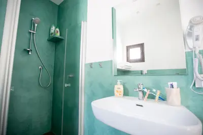 a bathroom with a white sink and a mirror at White Asses Rooms in Castellammare del Golfo