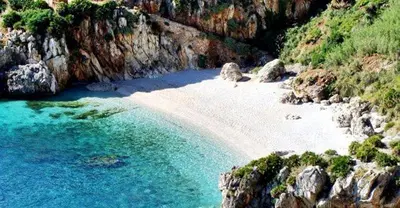a beach with blue water and a rocky cliff at Villa Laurum - Giardino degli allori - Castellammare del Golfo - Scopello in Castellammare del Golfo