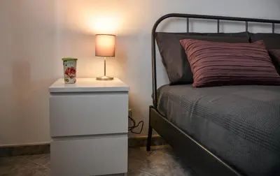 a bedroom with a bed and a nightstand with a lamp at Casa Pomelia in Castellammare del Golfo