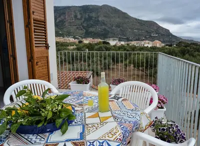 a table with a table cloth on a balcony with a view at Casa Pomelia in Castellammare del Golfo