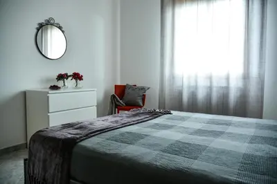 a bedroom with a bed and a mirror and a chair at Casa Pomelia in Castellammare del Golfo