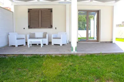 a patio with white chairs and a table at Suite Capaci in Capaci