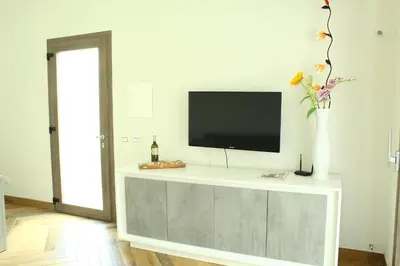 a living room with a tv and a vase with flowers at Suite Capaci in Capaci