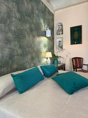 a bedroom with a bed with two green pillows at Azulè in San Vito lo Capo